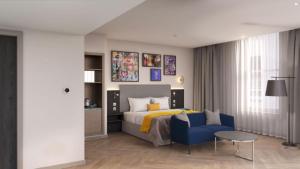 - une chambre avec un lit et une chaise bleue dans l'établissement Maldron Hotel Liverpool City Centre, à Liverpool