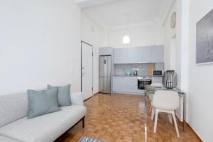 ein Wohnzimmer mit einem Sofa und einem Tisch sowie eine Küche in der Unterkunft Kipstay Apartments in Athen