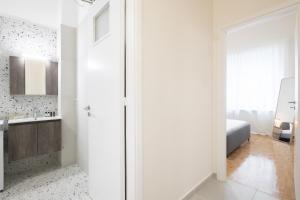 Baño blanco con lavabo y espejo en Kipstay Apartments, en Atenas
