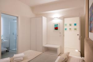 a white bedroom with a bed and a bathroom at Lo Studio di viale Lo Re camere & caffe’ in Lecce