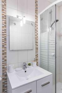 a white bathroom with a sink and a mirror at Appartement avec parking et terrasse Métro 7 et Paris in Villejuif +17 photos