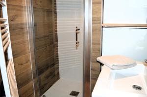 a shower with a glass door in a bathroom at La Tourelle - Balcon vue mer et terrasse plein sud in Saint-Aubin-sur-Mer