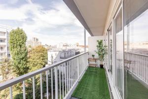 an apartment balcony with green flooring and large windows at Appartement avec parking et terrasse Métro 7 et Paris in Villejuif