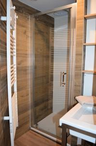 a shower with a glass door in a bathroom at La Tourelle - Balcon vue mer et terrasse plein sud in Saint-Aubin-sur-Mer