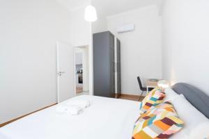 1 dormitorio con cama blanca y escritorio en Kipstay Apartments, en Atenas