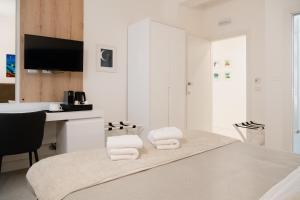 una camera bianca con un tavolo e asciugamani di Lo Studio di viale Lo Re camere & caffe’ a Lecce