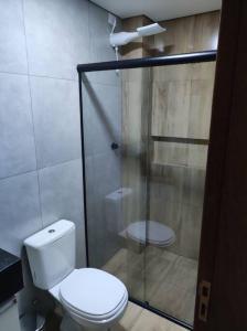 a bathroom with a toilet and a glass shower at Apartamento encantador 1 Quarto na Candangolândia in Brasilia