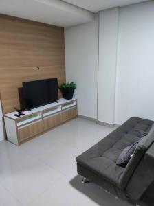a living room with a couch and a flat screen tv at Apartamento encantador 1 Quarto na Candangolândia in Brasilia
