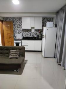 a living room with a couch and a refrigerator at Apartamento encantador 1 Quarto na Candangolândia in Brasilia