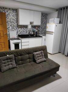 a living room with a couch and a kitchen at Apartamento encantador 1 Quarto na Candangolândia in Brasilia