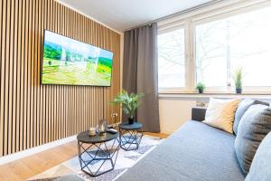 a living room with a blue couch and a large window at lionApartments Leverkusen in Leverkusen