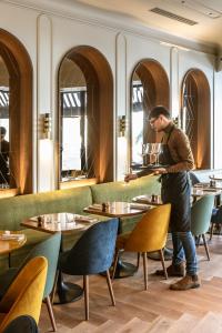 a man standing at a bar in a restaurant at Hotel Flanelles Paris in Paris