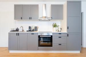 a kitchen with white cabinets and an oven at lionApartments Leverkusen in Leverkusen