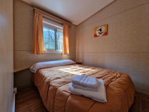 sypialnia z łóżkiem z ręcznikami w obiekcie CAMPING RAMALES w mieście Ramales de la Victoria