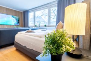 a bedroom with a bed and a table with a lamp at lionApartments Leverkusen in Leverkusen