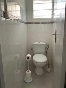 Un baño blanco con inodoro y ventana. en Appartement Kay Nephile - vue mer - Grande Anse, en Les Anses-dʼArlet 10 fotos más