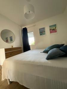 Un dormitorio con una cama blanca con dos almohadas. en Appartement Kay Nephile - vue mer - Grande Anse, en Les Anses-dʼArlet