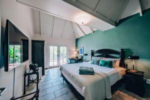sypialnia z dużym łóżkiem i niebieskimi ścianami w obiekcie Kura Botanica Hotel w mieście Willemstad