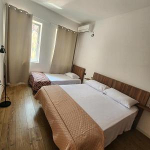 a hotel room with two beds and a window at Rino's Apartment 1 in Shkodër
