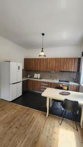 a kitchen with a table and a white refrigerator at Rino's Apartment 1 in Shkodër