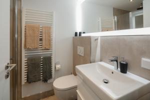 a white bathroom with a toilet and a sink at die ELF in Norderney