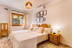 1 dormitorio con 2 camas y mesita de noche en Casa Far, en Portopetro