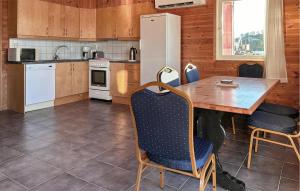 SjernarøyにあるNice Apartment In Sjernarøyのテーブルと椅子と冷蔵庫のあるキッチン