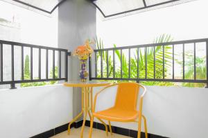 a table and a chair and a vase on a balcony at OYO 354' 32 Guest House in Batu