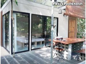 a screened in porch of a house with a table at Gibbon Retreat Bentong in Bentong