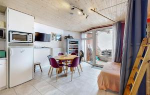 cocina y comedor con mesa y sillas moradas en Gorgeous Apartment In Bagnres-de-bigorre With Kitchen, en Bagnères-de-Bigorre