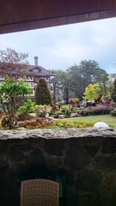 a view of a garden with a building in the background at Unit 551,Privately Owned, Superior Room At the Forest Lodge Camp John Hay, Mountain View, 2 Double Beds in Baguio