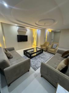sala de estar con 2 sofás y TV de pantalla plana en Lovely High Quality Self Check-in Apartments شقق سلام بالدخول الذاتي en Medina