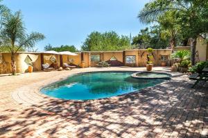 a swimming pool in a yard with a patio at Bolivia Lodge in Polokwane