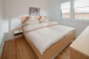 a bedroom with a bed with white sheets and a window at die ELF in Norderney