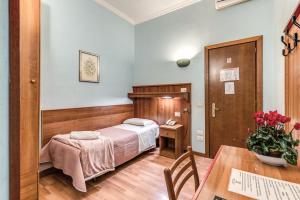 ローマにあるホテル アルタヴィッラのベッドルーム1室(ベッド1台、テーブル、テーブルサイドシックスシックス付)