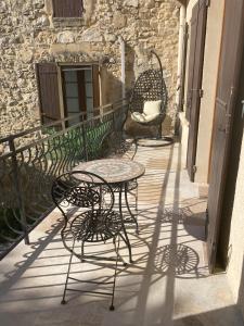 um pátio com mesas e cadeiras numa varanda em La belle Maison d'Hôtes d'Aurélie en pleine campagne et proche de tout em Roquemaure