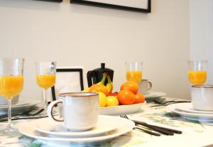 uma mesa com copos de sumo de laranja e uma taça de laranjas em Apartamento Marques de Zafra - Ventas em Madri