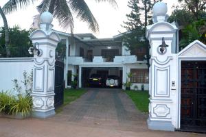 a white house with a gate and a driveway at The Kings Villa in Wattala