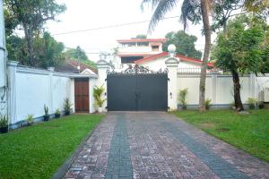 una entrada que conduce a una casa con una puerta negra en The Kings Villa, en Wattala