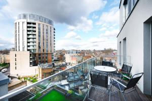 a balcony with a table and chairs on a building at Modern Serviced 3-bedroom flat in East London in London