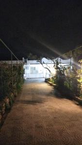 eine leere Einfahrt in der Nacht mit einem weißen Gebäude in der Unterkunft B&B vacanze Mille Colori in Cinisi