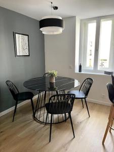 une salle à manger avec une table et des chaises dans une pièce dans l'établissement Escale Concarnoise, Confort et Centre ville à pied, à Concarneau