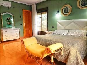 ein Schlafzimmer mit einem Bett und einem Stuhl darin in der Unterkunft Hostal Restaurante Solaire in Castañar de Ibor