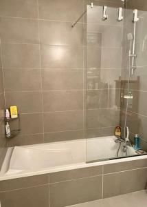 W łazience znajduje się wanna i przeszklony prysznic. w obiekcie 21 - Très agréable rdc avec terrasse et parking w mieście Bandol