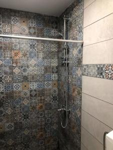 a bathroom with a shower with tiles on the wall at Kalavrita Winter Retreat - Homely Spacious Chalet in Áno Vlasía