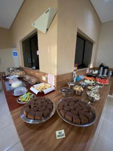 uma mesa com brownies e outros alimentos em Pousada Kaluanã em Olímpia