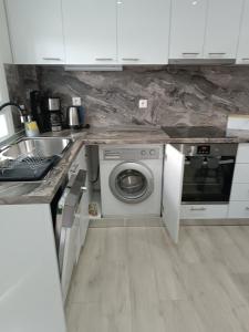 a kitchen with a washing machine and a sink at Myrto 's sea view in Kallithea Halkidikis +8 photos