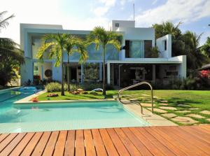 ein Haus mit Pool davor in der Unterkunft Casa de Praia em Interlagos - 4 suítes a poucos metros do mar in Camaçari
