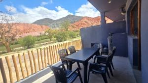 a table and chairs on a balcony with a view of mountains at El cielo en Purmamarca Duplex 3 in Purmamarca