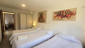 a bedroom with three beds and a painting on the wall at El cielo en Purmamarca Duplex 3 in Purmamarca